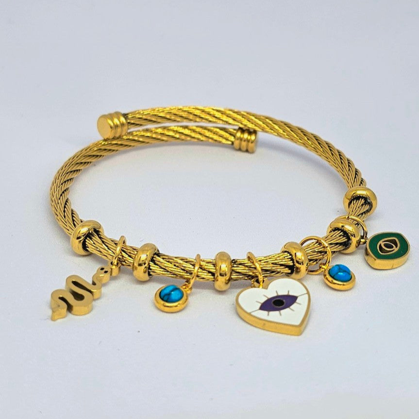 Gold bracelet with charms on a light gray background