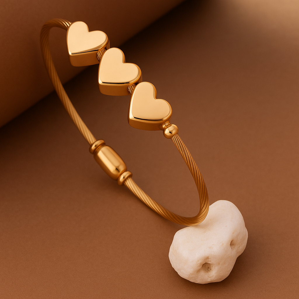Gold bracelet with heart-shaped charms on a brown background