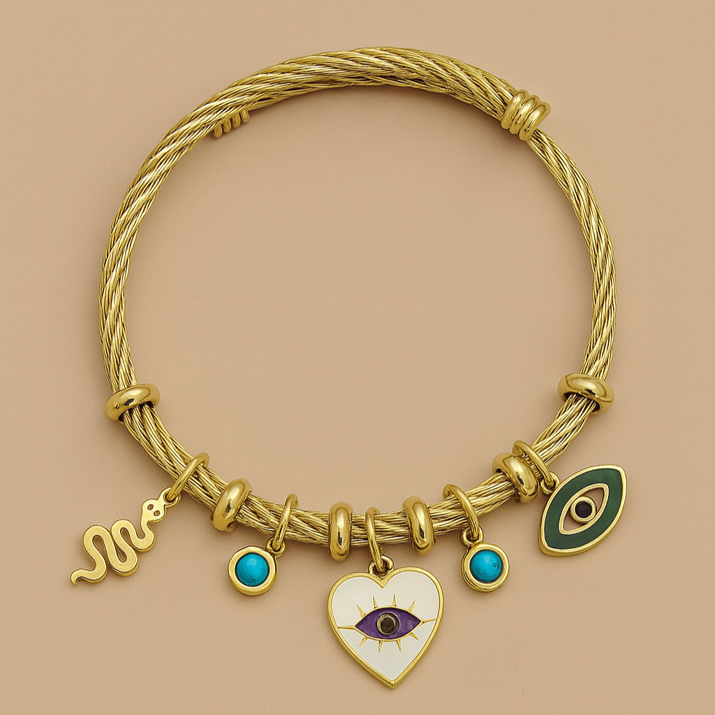 Gold bracelet with various charms on a beige background