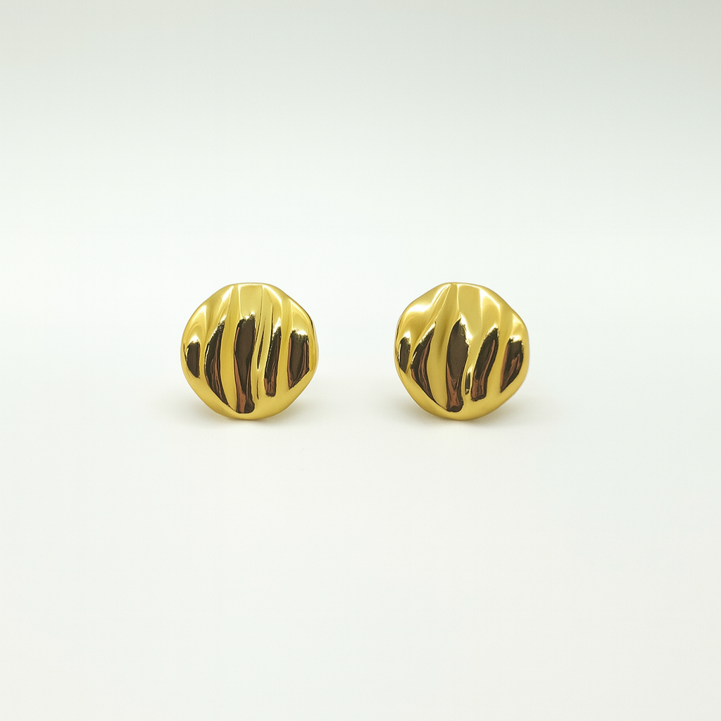 Pair of gold earrings with a textured design on a light gray background