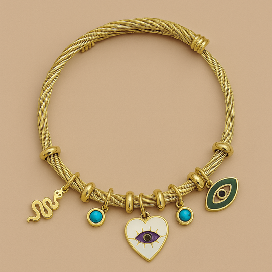 Gold bracelet with various charms on a beige background

