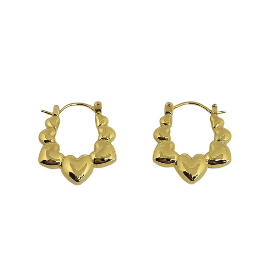 Gold heart-shaped hoop earrings on a light gray background

