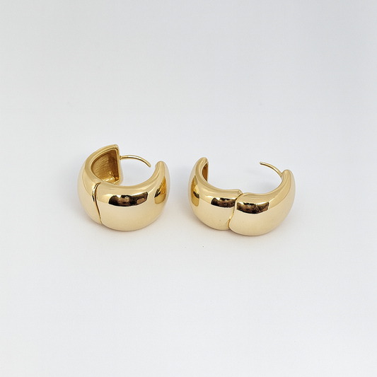 Gold hoop earrings on a light gray background

