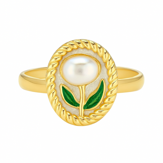 Gold ring with a pearl and green leaves on a white background

