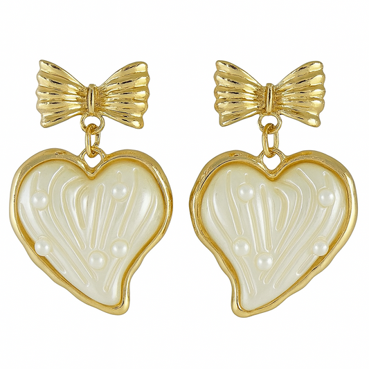 Pair of earrings with gold bows and heart-shaped white stones on a white background

