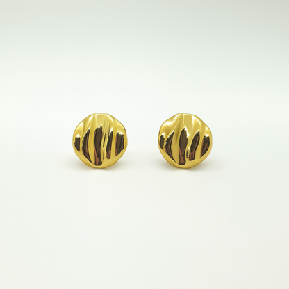 Pair of gold earrings with a textured design on a light gray background

